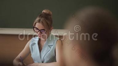 女老师在<strong>小朋友</strong>面前.. 教室里的漂亮老师坐在桌子前问孩子们。 教育